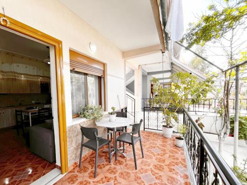 a room with a table and chairs on a balcony at Beach & Chill Apartments in Vlorë