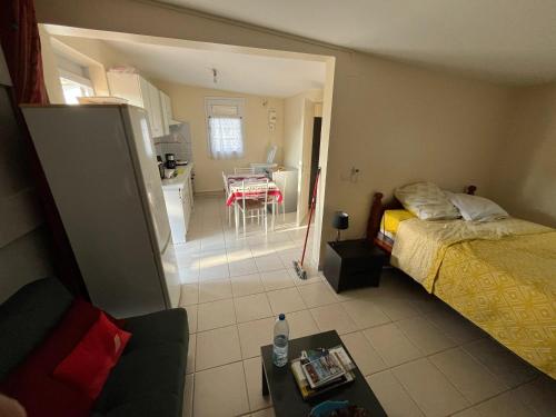 1 dormitorio con 1 cama y cocina con mesa en Studio avec jardin clos et wifi a Le Lamentin a 5 km de la plage en Le Lamentin