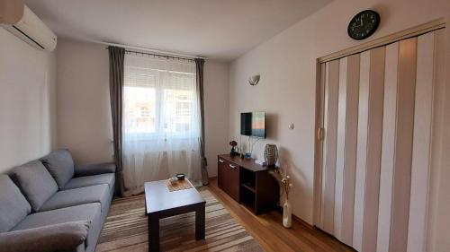 een woonkamer met een bank en een tafel bij LERA Apartment in Zagreb