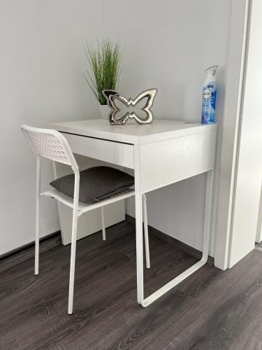 a white desk with a chair and a plant at Apartments im Herzen von Velbert in Velbert