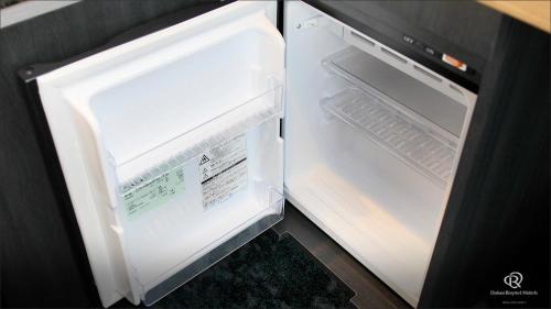 an empty refrigerator with its door open in a kitchen at Daiwa Roynet Hotel Hachinohe in Hachinohe