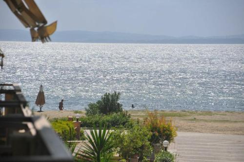 a view of the ocean with people walking on the beach at Halkidiki Greece vacation home in Yerakiní
