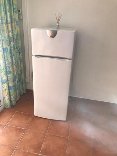 - un petit réfrigérateur blanc dans un coin de chambre dans l'établissement Sognu di Mare Residence, à Linguizzetta