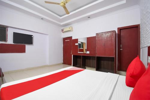 een slaapkamer met een groot bed met rode kussens bij OYO Flagship Hotel Preet Palace in Rānchī