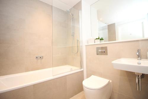 a bathroom with a toilet and a shower and a sink at Coastal apartment sea views in Saint Merryn