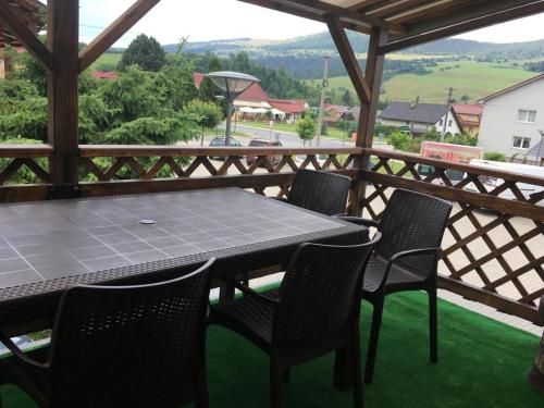 a table and chairs on a porch with a view of a valley at Penzión Janka in Zuberec