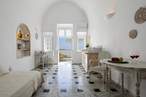 une chambre blanche avec une table et une cuisine dans l'établissement MyBoZer Hotel Kallisto, à Imerovigli