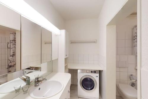 a white bathroom with a washing machine and a washer at Executive 1 bedroom flat, city center (Hammer 1) in Zürich