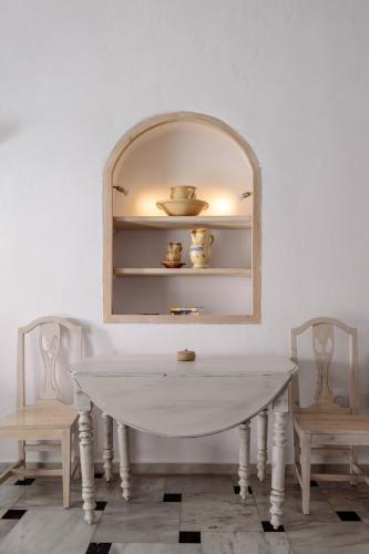 a white table with two chairs and a mirror at MyBoZer Hotel Kallisto in Imerovigli