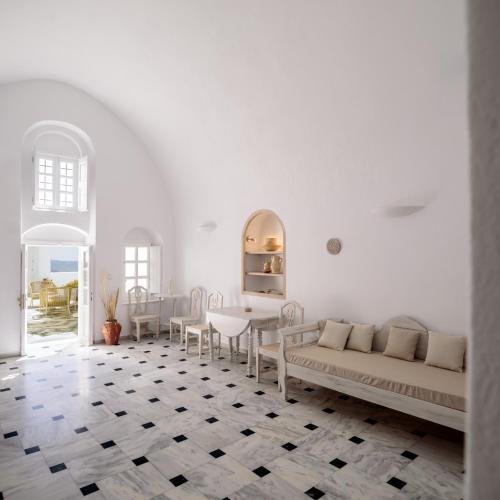a white living room with a couch and a table at MyBoZer Hotel Kallisto in Imerovigli