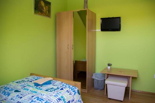 1 dormitorio con 1 cama, escritorio y TV en ROOMS free - Zagorje, en Bedekovčina