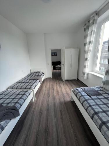 2 camas en una habitación con suelo de madera en Apartments im Herzen von Velbert, en Velbert