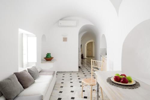 a living room with a couch and a table with fruit on it at MyBoZer Hotel Kallisto in Imerovigli