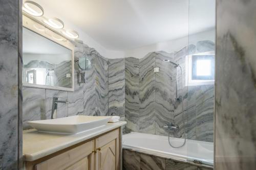 a bathroom with a sink and a shower and a tub at MyBoZer Hotel Kallisto in Imerovigli