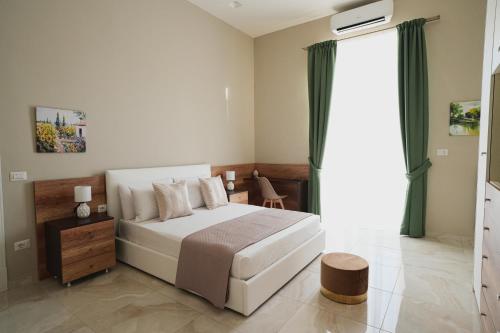 um quarto com uma cama branca e uma grande janela em ENJOY Napoli - Exclusive Apartment em Nápoles