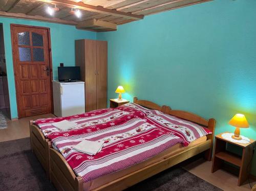 a bedroom with a bed with a red blanket on it at Penzión Janka in Zuberec