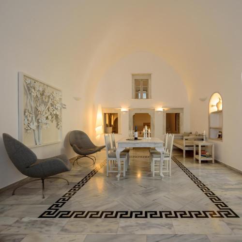 a dining room with a white table and chairs at MyBoZer Hotel Kallisto in Imerovigli