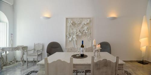 a dining room with a table with a bottle of wine and candles at MyBoZer Hotel Kallisto in Imerovigli