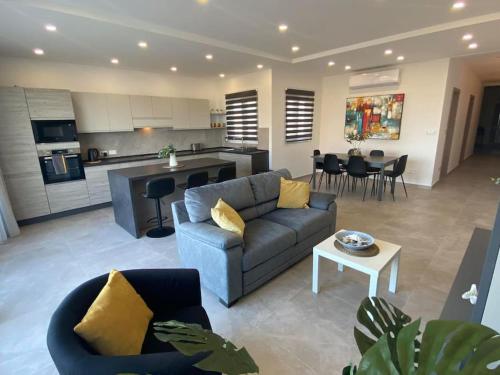 un soggiorno con divano e una cucina di Yellow Hill Penthouse a Żebbuġ