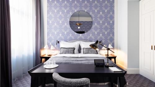 a bedroom with a bed with a desk and a wall at TORTUE Hamburg in Hamburg