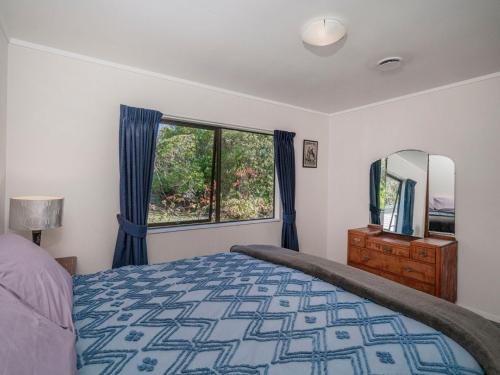 - une chambre avec un lit et une grande fenêtre dans l'établissement Seashells Bach - Whangamatā Holiday Home, à Whangamata