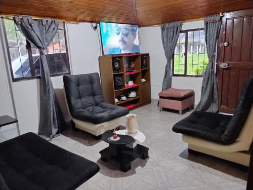 a living room with two chairs and a tv at Casa Campestre Adela in Suesca