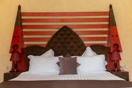 a bed with a large wooden headboard with two lamps at Riad Al Madina in Essaouira