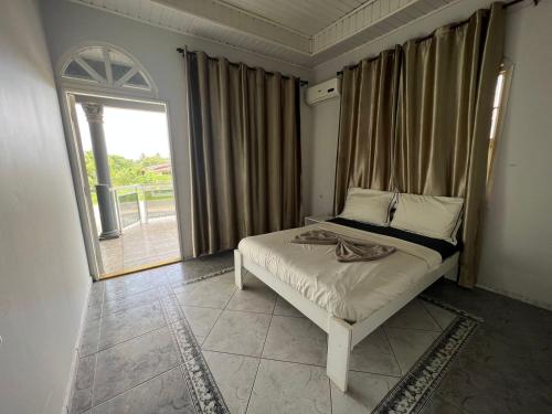 a bedroom with a bed and a large window at Luxueus appartement Wanica, Welgedacht C in Wanica