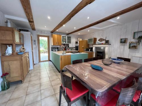 une grande cuisine avec une table et des chaises en bois dans l'établissement 310 -Maison de charme 8personnes proche des plages, à Fréhel