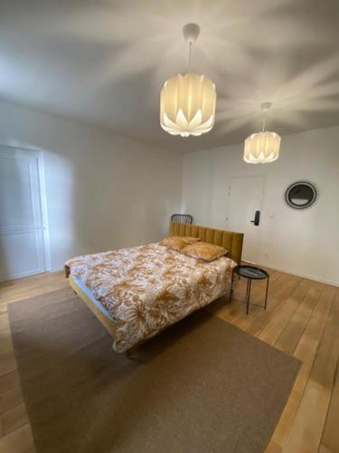 a bedroom with a bed in a room with two lights at Chez Victor H in Amiens
