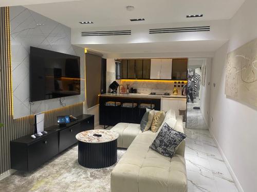 a living room with a couch and a kitchen at PROOF RESIDENCE in Lekki