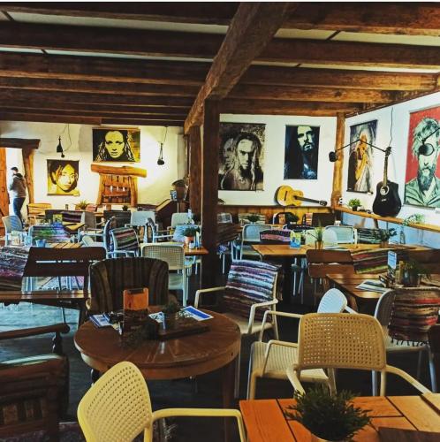 a restaurant with tables and chairs and paintings on the walls at Przystań Tło dla Mew in Rydzewo