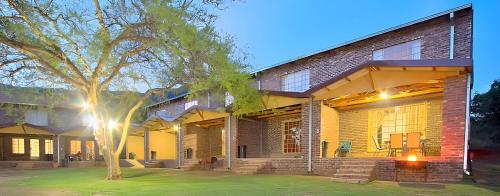 a brick building with a tree in front of it at Elangeni Holiday Resort in Waterval Boven