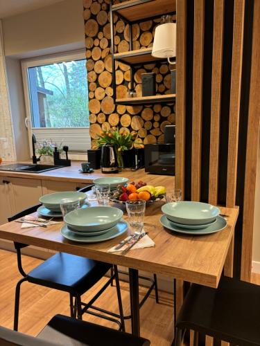 drewniany stół z talerzami jedzenia w kuchni w obiekcie Ostródzkie Zacisze Ośrodek Arizona w Ostródzie