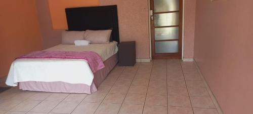 a bedroom with a bed and a tiled floor at M&T Guesthouse in Orkney