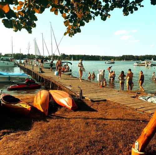 a group of people on a dock in the water at Przystań Tło dla Mew in Rydzewo