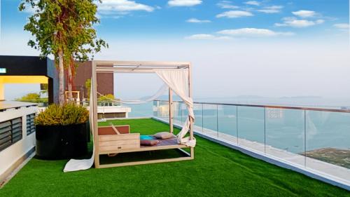 a balcony with green grass and a hammock at Apartment in Georgetown 3BR-10pax in Jelutong