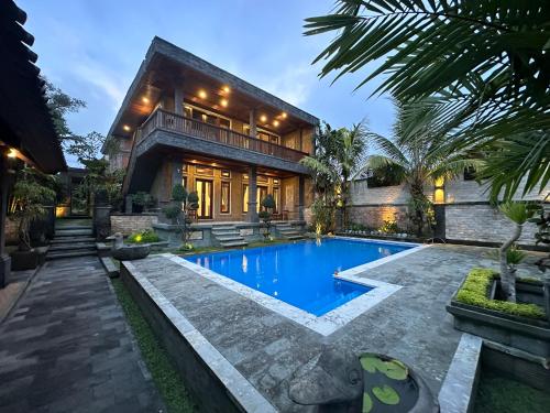 a house with a swimming pool in front of a house at Bupon House Jepun Room in Gianyar