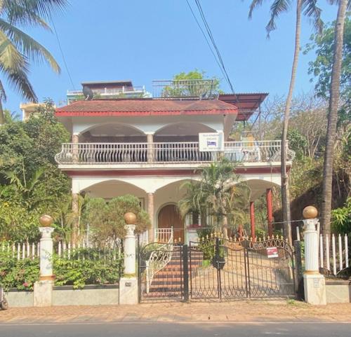 a house with a gate with a balcony on it at Felix Homestay Enclave in Panaji