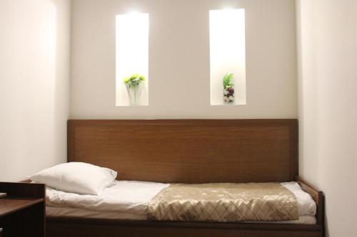 a bedroom with a bed with two windows at Luxor Garden in Batumi