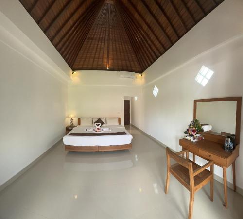 a bedroom with a bed and a wooden table at Bupon House Jepun Room in Gianyar