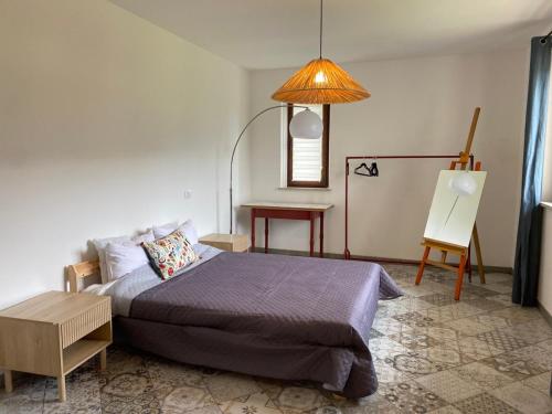 um quarto com uma cama, uma mesa e um candeeiro em SUNRISE HILL B&B em Menestrello
