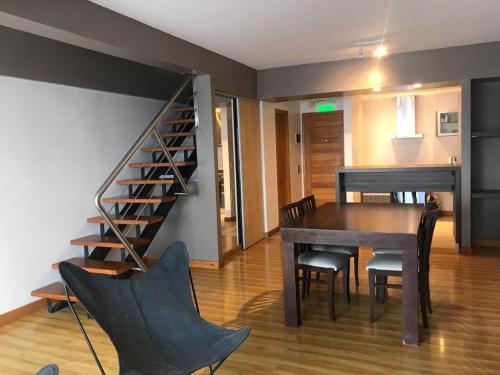 a dining room with a table and a staircase at Polo Sur Apartamentos in Ushuaia