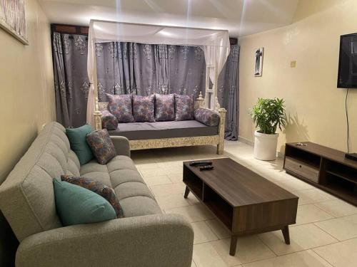 a living room with a couch and a table at Golden Beachfront Apartment Diani in Ukunda
