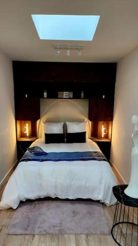 une chambre avec un grand lit avec une lucarne dans l'établissement La Tanière Lens est, à Sallaumines