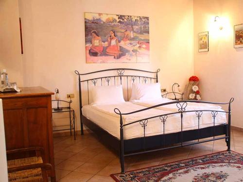 a bedroom with a bed and a painting on the wall at DA ROSA B&B in Neviglie
