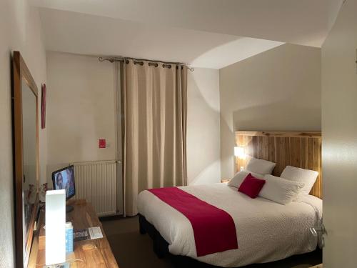 a hotel room with a bed and a television at Logis Hôtel de France & Restaurant Pamiers in Pamiers
