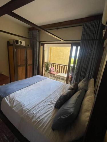 a bed with pillows in a bedroom with a window at Golden Beachfront Apartment Diani in Ukunda