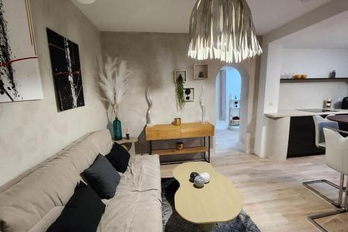 een woonkamer met een bank en een tafel bij La Tanière Lens est in Sallaumines