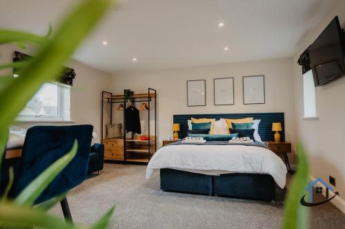 ein Schlafzimmer mit einem blauen Bett und einem TV in der Unterkunft Shambles Retreat - King or twin beds free parking x2 wifi corporates in Bradford on Avon